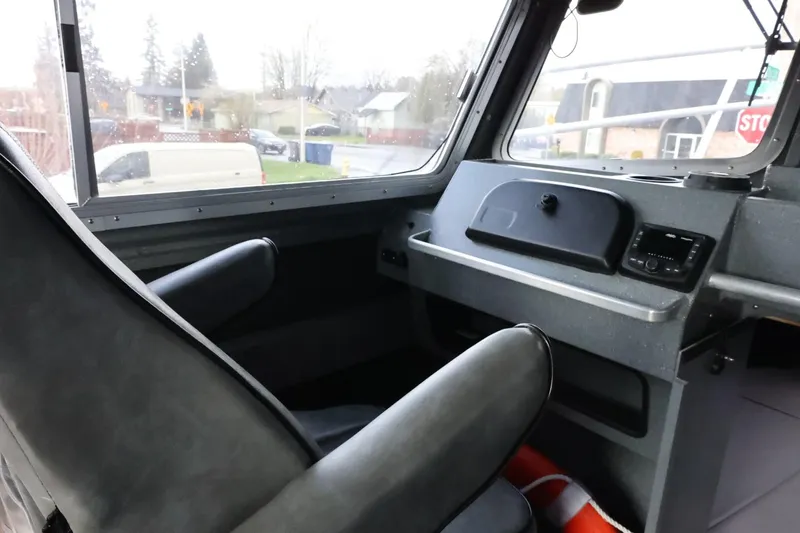 Slide: The Image of Interior of a 2015 Duckworth 26 Offshore boat, featuring a captain's seat and control panel. - 36