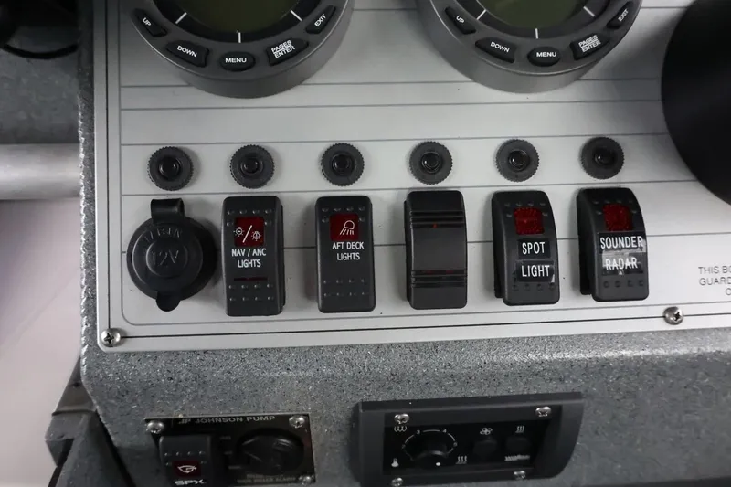 Slide: The Image of Control panel of a 2015 Duckworth 26 Offshore boat with various switches and dials. - 39