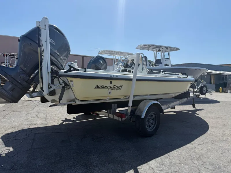 Slide: The Image of 2003 Action Craft 1820 boat on trailer, parked outdoors under clear sky. - 14
