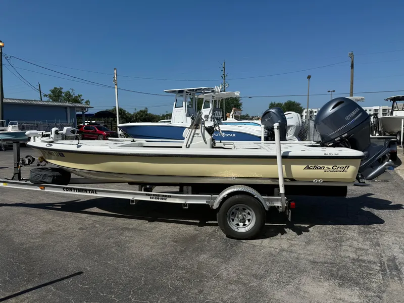 Slide: The Image of 2003 Action Craft 1820 boat on trailer, parked outdoors under clear blue sky. - 3