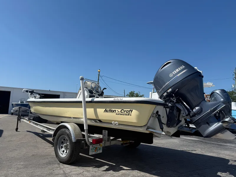 Slide: The Image of 2003 Action Craft 1820 boat on trailer with Yamaha outboard motor, parked outdoors. - 4