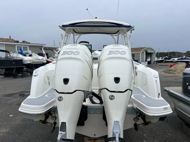 Slide: The Image of 2018 Boston Whaler 270 Vantage with twin 300 horsepower engines, docked at a marina. - 12