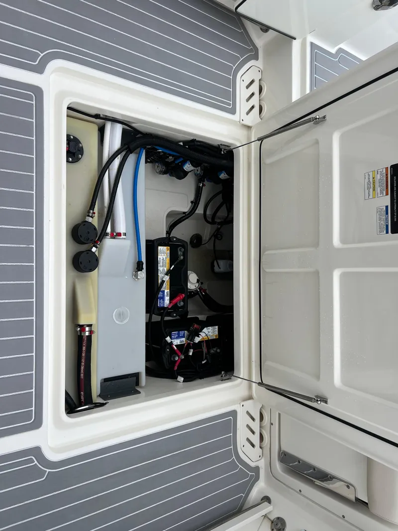 Slide: The Image of 2018 Boston Whaler 270 Vantage boat storage compartment with visible wiring and battery. - 14
