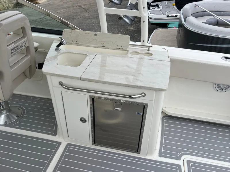 Slide: The Image of 2018 Boston Whaler 270 Vantage boat interior with sink, countertop, and storage. - 18