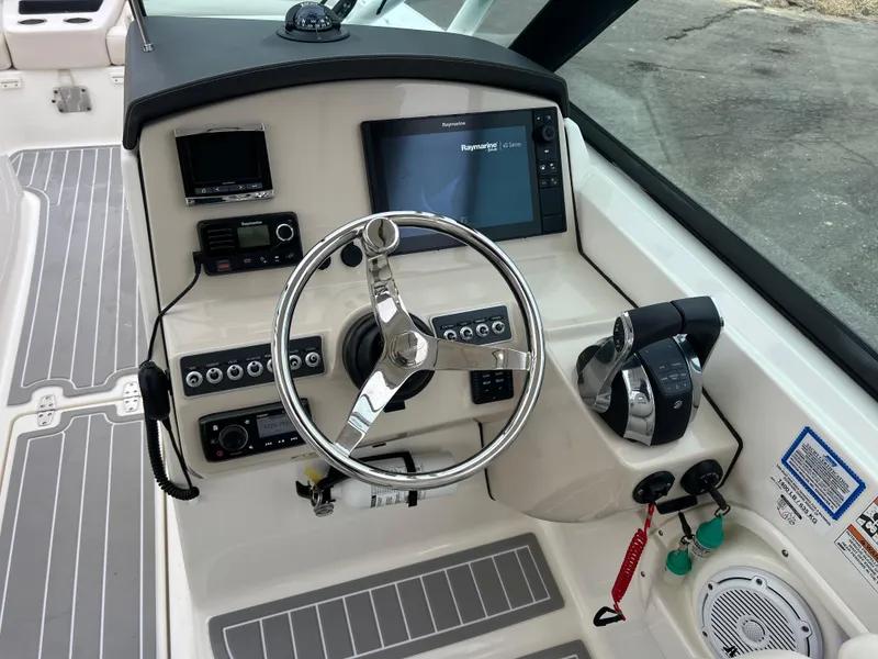 Slide: The Image of 2018 Boston Whaler 270 Vantage helm with steering wheel, controls, and navigation display. - 19