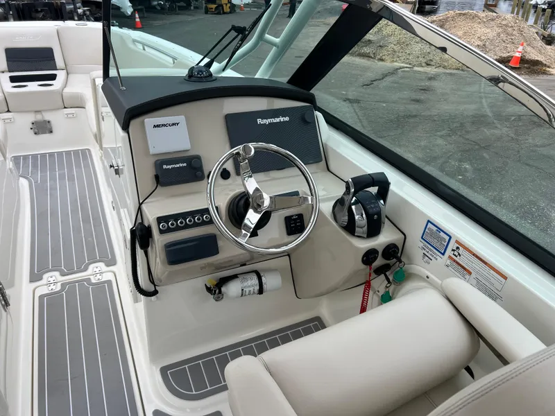 Slide: The Image of 2018 Boston Whaler 270 Vantage boat helm with steering wheel and control panel. - 21