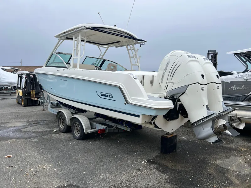 Slide: The Image of 2018 Boston Whaler 270 Vantage boat on trailer with dual engines, parked outdoors. - 9