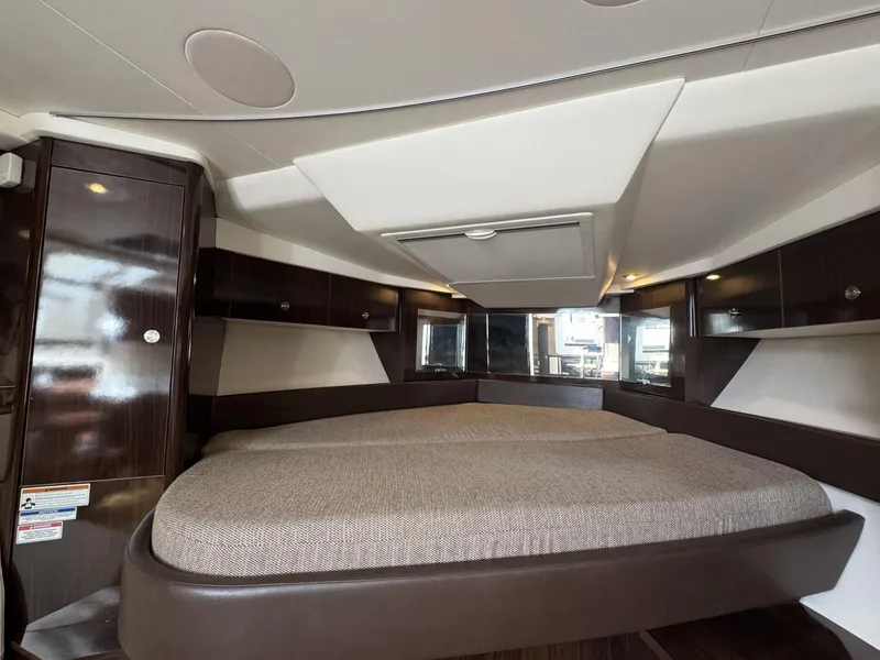 Slide: The Image of 2019 Sea Ray Sundancer 350 Coupe interior cabin with bed and storage cabinets. - 11