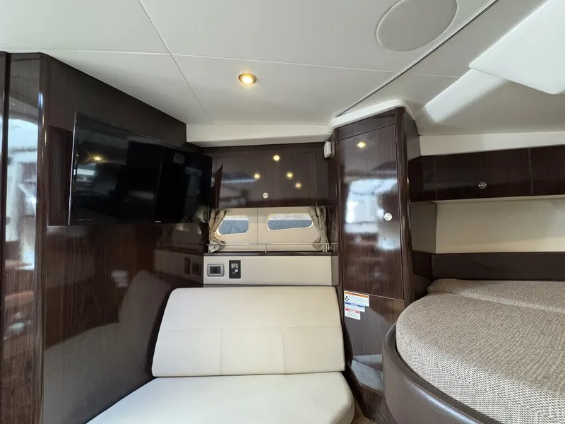 Slide: The Image of 2019 Sea Ray Sundancer 350 Coupe interior with TV, seating, and bed. - 12