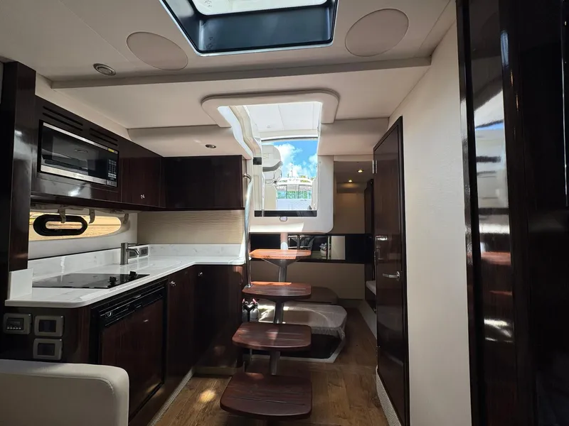 Slide: The Image of 2019 Sea Ray Sundancer 350 Coupe interior with modern kitchen and skylight. - 13
