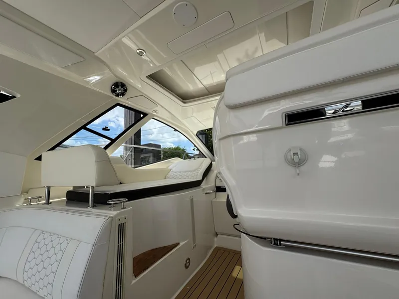 Slide: The Image of Interior of 2019 Sea Ray Sundancer 350 Coupe, featuring sleek white seating and modern design. - 5