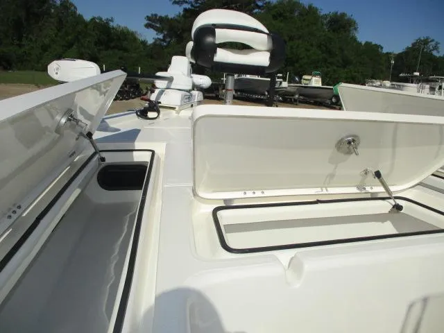 Slide: The Image of 2025 Skeeter SX241 boat with open storage compartments and seating, set against a lush green backdrop. - 11