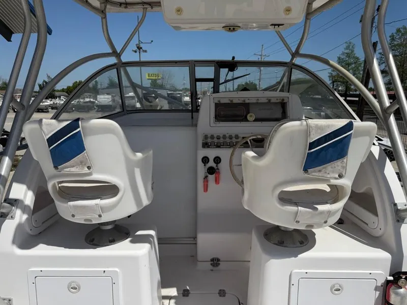 Slide: The Image of 2000 Pro-Line 27 Walk boat cockpit with dual white seats and control panel. - 12