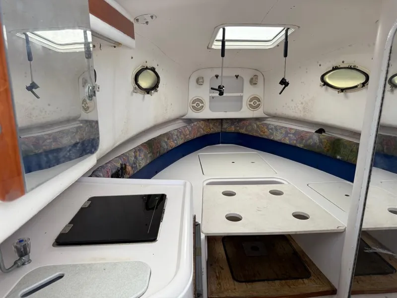 Slide: The Image of Interior of a 2000 Pro-Line 27 Walk boat, featuring a compact cabin layout. - 22