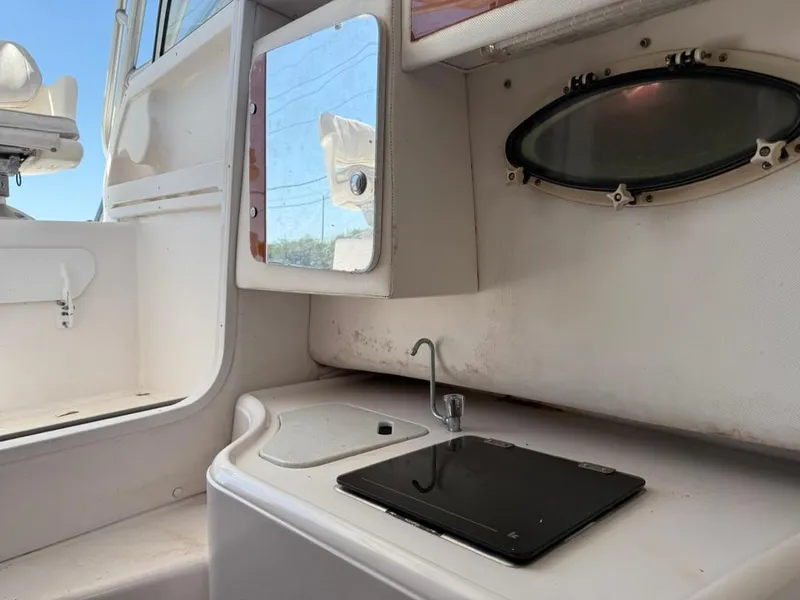 Slide: The Image of 2000 Pro-Line 27 Walk boat interior with sink, mirror, and porthole window. - 23