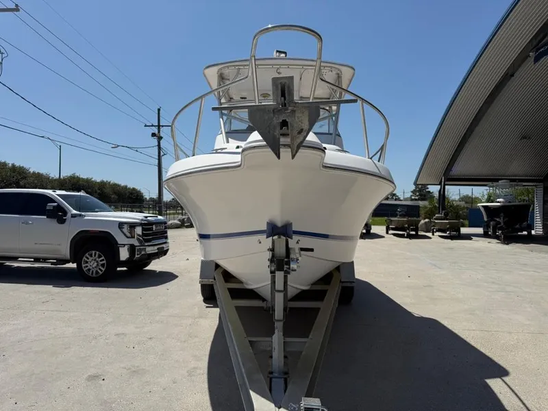 Slide: The Image of 2000 Pro-Line 27 Walk boat on trailer, parked outdoors near a truck and building. - 5