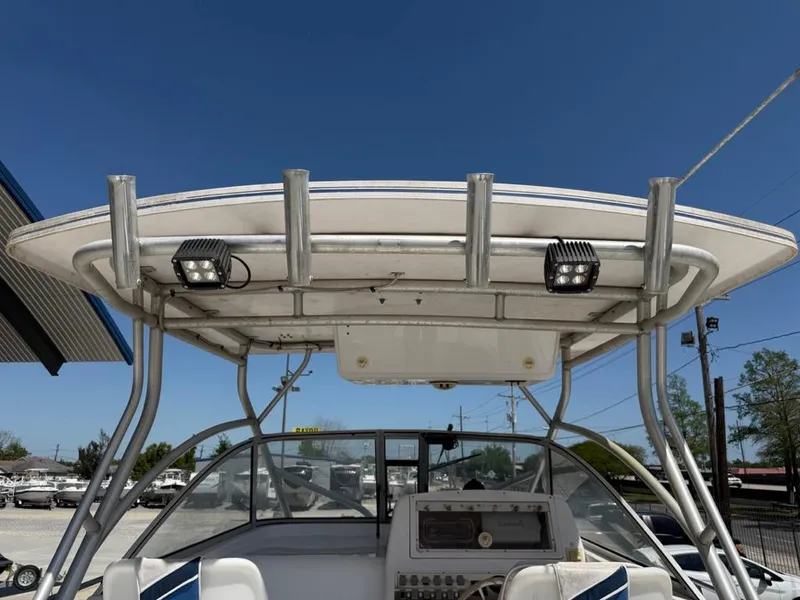Slide: The Image of 2000 Pro-Line 27 Walk boat with T-top and electronics, docked under clear blue sky. - 8