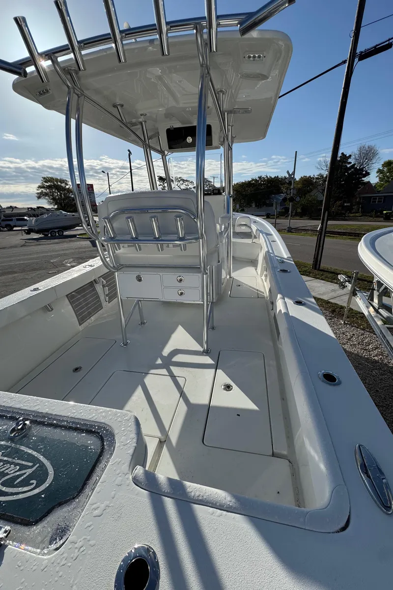 Slide: The Image of 2025 Pair Customs 24 Center Console DV boat with T-top and seating, docked outdoors. - 3