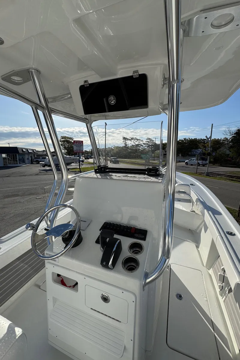 Slide: The Image of 2025 Pair Customs 24 Center Console DV boat interior with steering wheel and control panel. - 4