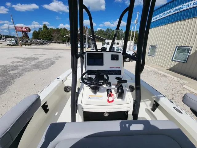 Slide: The Image of 2025 Pathfinder 2300 HPS boat interior with steering console and controls, parked outdoors. - 21