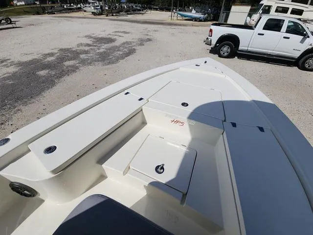 Slide: The Image of 2025 Pathfinder 2300 HPS boat interior with storage compartments, parked near a white truck. - 24