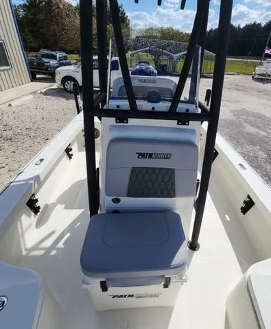 Slide: The Image of 2025 Pathfinder 2300 HPS boat interior with seating and console, parked outdoors. - 28