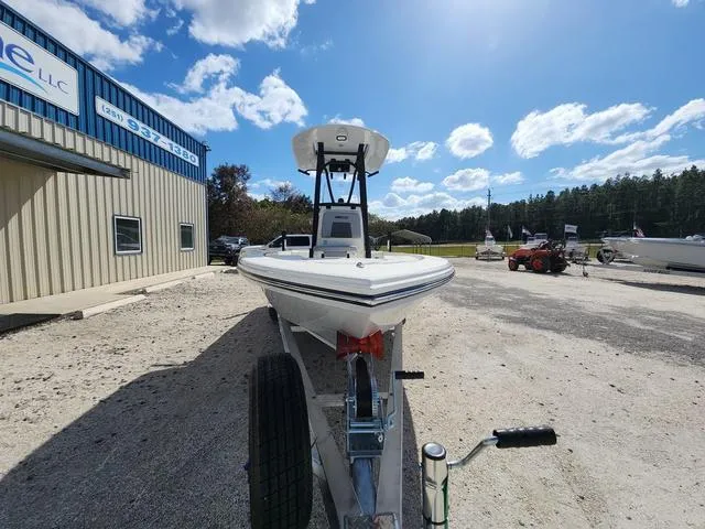 Slide: The Image of 2025 Pathfinder 2300 HPS boat on trailer, parked outside under a clear blue sky. - 3