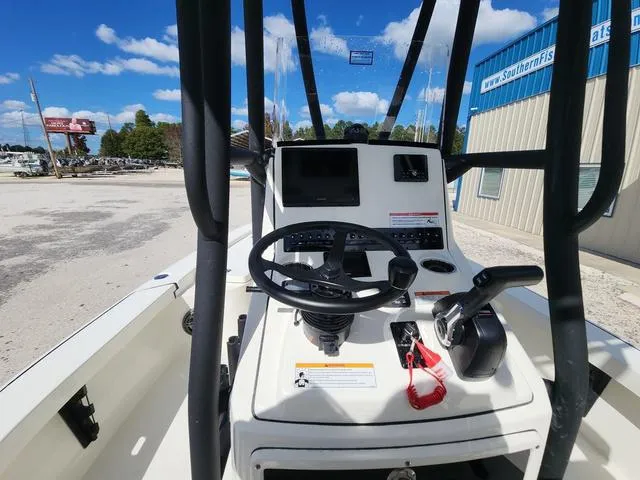 Slide: The Image of 2025 Pathfinder 2300 HPS boat console with steering wheel and controls, docked outdoors. - 35