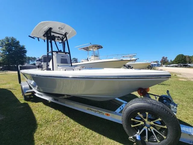 Slide: The Image of 2025 Pathfinder 2300 HPS boat on trailer, parked on grass under clear blue sky. - 5