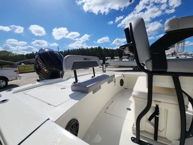 Slide: The Image of 2025 Pathfinder 2300 HPS boat interior with seating and motor, under a clear blue sky. - 9