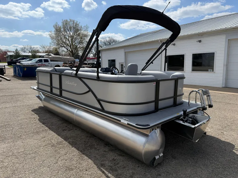 Slide: The Image of 2025 Bentley Pontoons LE 200 CW pontoon boat parked outdoors near a white building. - 7