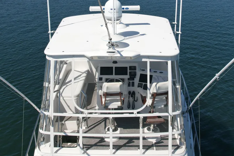 Slide: The Image of 2006 Cabo 40 Flybridge boat with dual helm seats on calm water. - 11