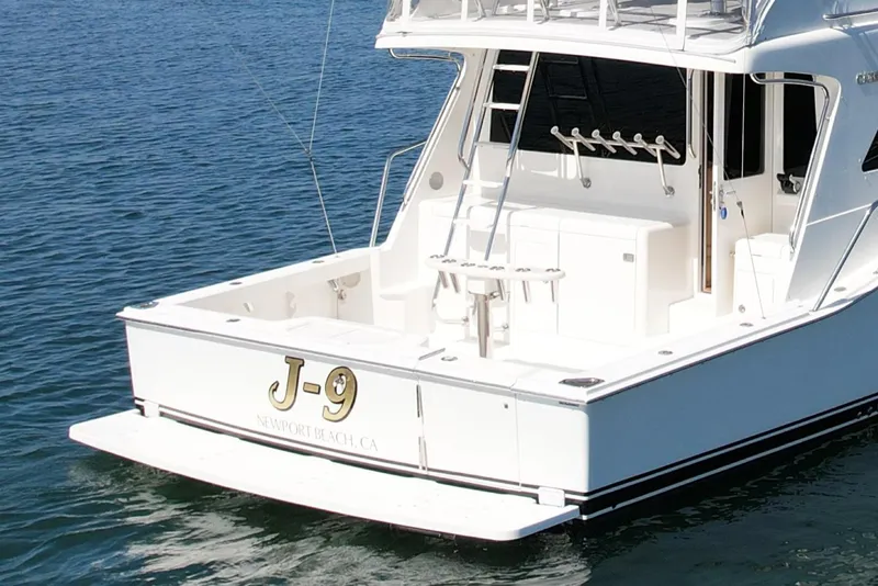 Slide: The Image of 2006 Cabo 40 Flybridge yacht on water, rear view with fishing setup. - 12
