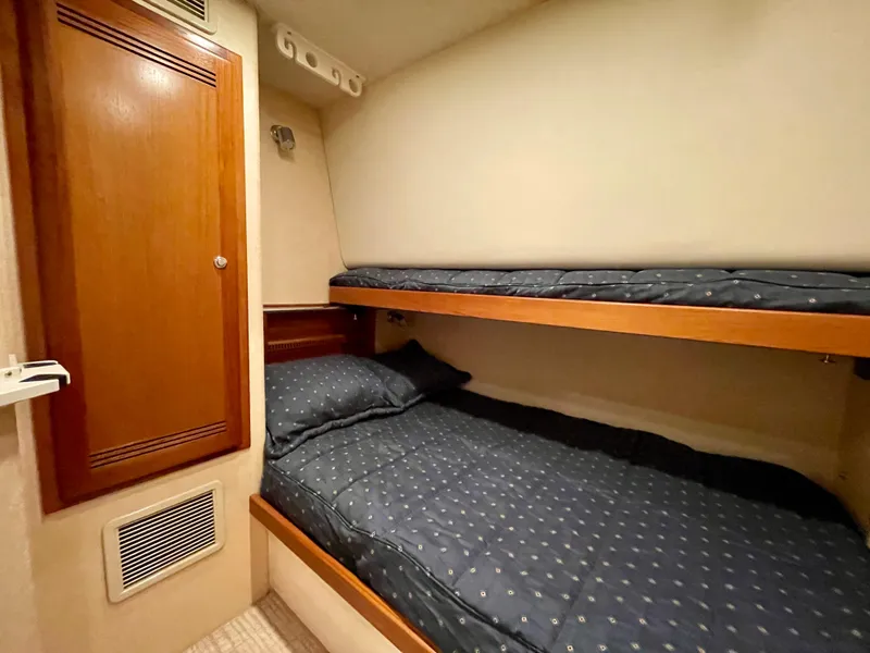Slide: The Image of 2006 Cabo 40 Flybridge cabin with bunk beds and wooden cabinetry. - 17