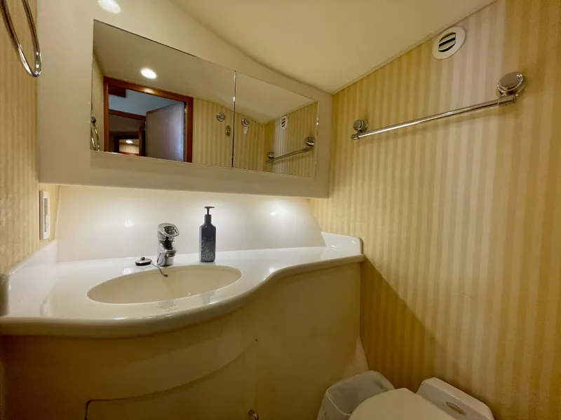 Slide: The Image of 2006 Cabo 40 Flybridge bathroom with striped wallpaper, mirror, and sink. - 21