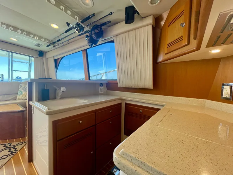 Slide: The Image of Interior of 2006 Cabo 40 Flybridge yacht with modern kitchen and fishing rods. - 25