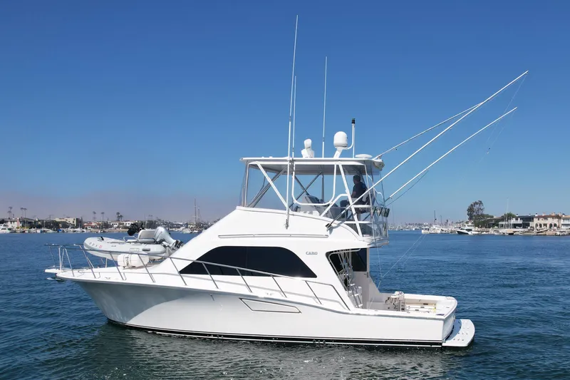 Slide: The Image of 2006 Cabo 40 Flybridge yacht on calm water under clear blue sky. - 3
