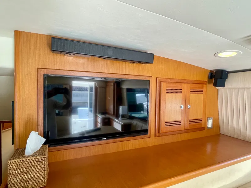 Slide: The Image of Interior of 2006 Cabo 40 Flybridge with TV and wooden cabinetry. - 33