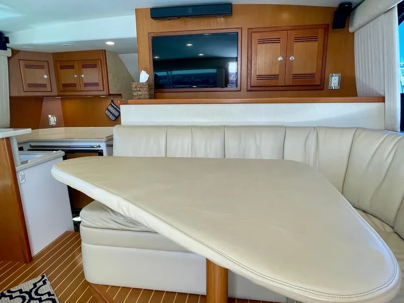 Slide: The Image of Luxurious interior of 2006 Cabo 40 Flybridge yacht with leather seating and wooden cabinetry. - 35