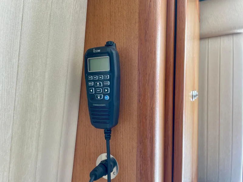 Slide: The Image of Icom radio handset mounted on a wooden panel inside a 2006 Cabo 40 Flybridge. - 39