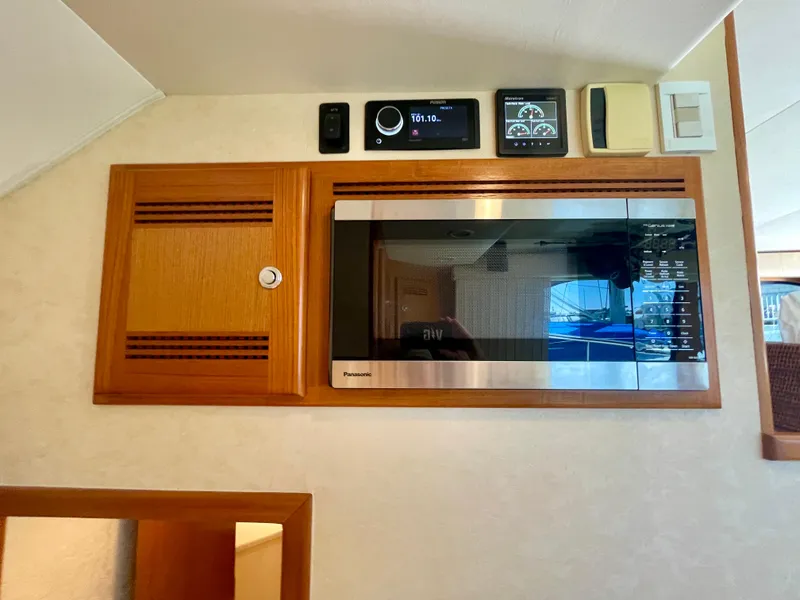 Slide: The Image of 2006 Cabo 40 Flybridge interior with microwave and control panel. - 48