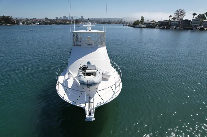 Slide: The Image of 2006 Cabo 40 Flybridge yacht on calm water, showcasing sleek design and spacious deck. - 6