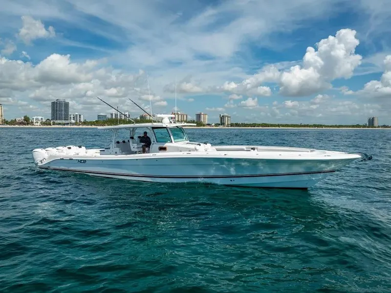 Slide: The Image of 2019 HCB 53 Sueños boat on open water under a partly cloudy sky. - 2