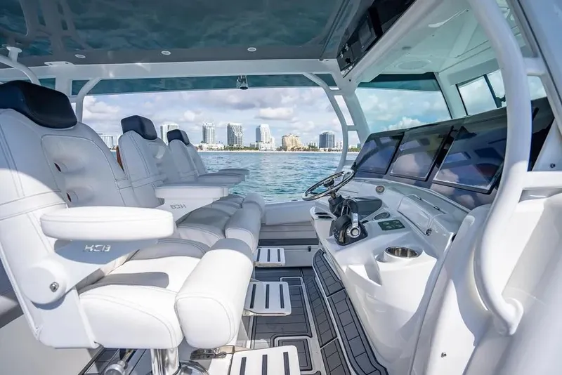 Slide: The Image of 2019 HCB 53 Sueños luxury boat interior with modern helm and seating, city skyline in background. - 20