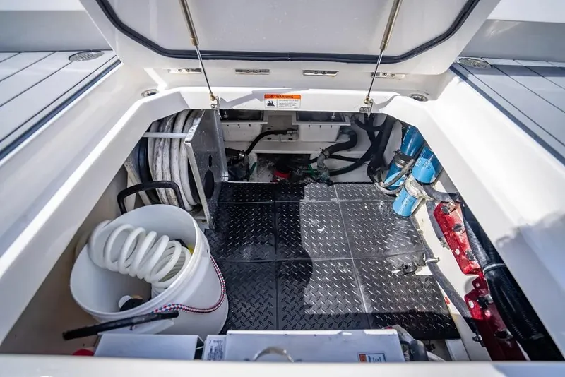 Slide: The Image of 2019 HCB 53 Sueños boat storage compartment with equipment and coiled hose. - 33