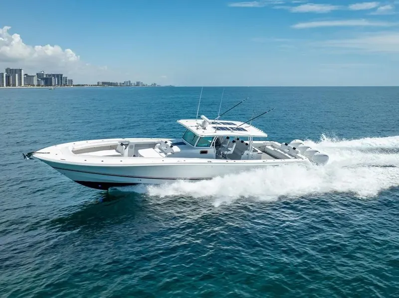 Slide: The Image of 2019 HCB 53 Sueños boat cruising on open ocean near city skyline. - 5