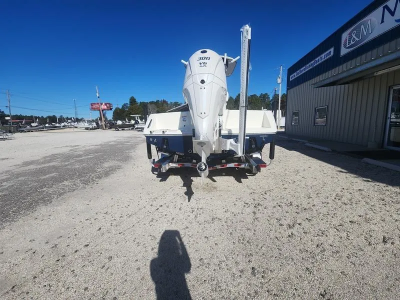 Slide: The Image of 2025 Pathfinder 2400 Open boat on trailer, parked outside a building on a sunny day. - 14