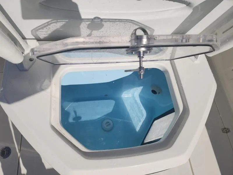 Slide: The Image of Livewell compartment on 2025 Pathfinder 2400 Open boat, featuring a clear lid and blue interior. - 8