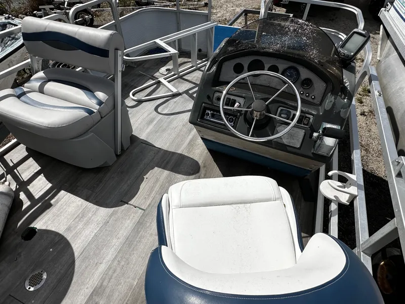 Slide: The Image of 1994 Sylvan Adventure boat interior with steering wheel and seating. - 10
