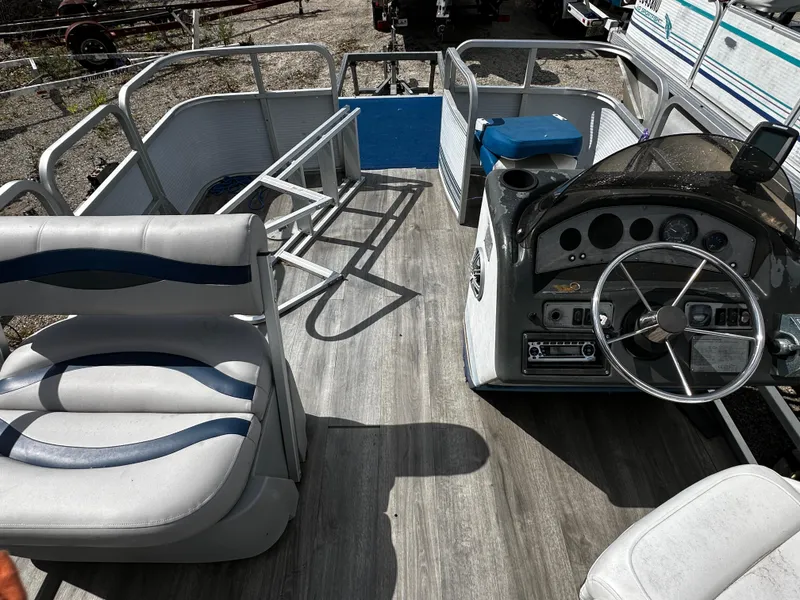 Slide: The Image of 1994 Sylvan Adventure pontoon boat interior with steering console and seating. - 11